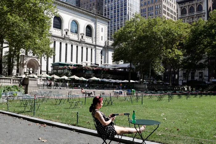 A woman sits with her feet up in Bryant Park as extreme warm weather hits New York, August 12th, 2021